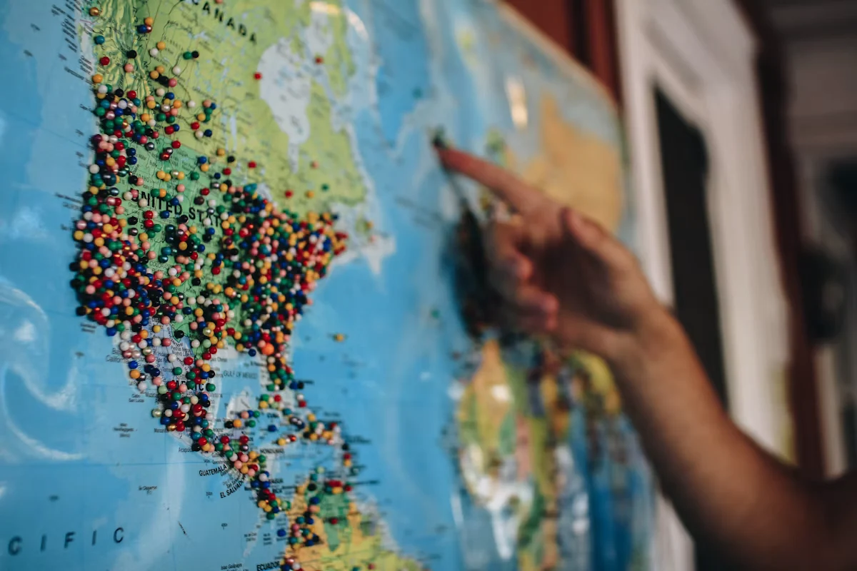 Person pointing at a map with location pins, representing location-based search targeting